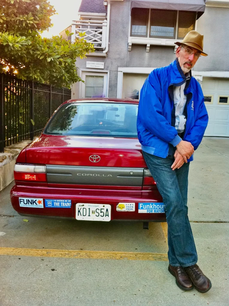 The Big Guy in front of his little red Corolla